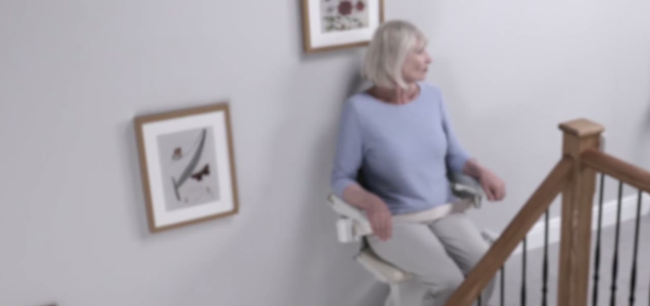 A woman riding a stair lift at home